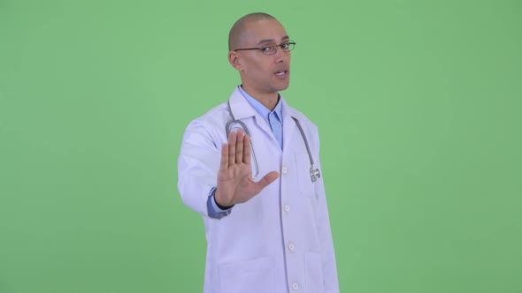 Serious Bald Multi Ethnic Man Doctor Showing Stop Gesture