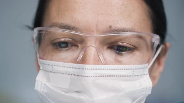 Eyes of Female Doctor in Face Mask and Goggles