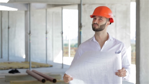 Architector Looks At The Plan Of The Building Under Construction