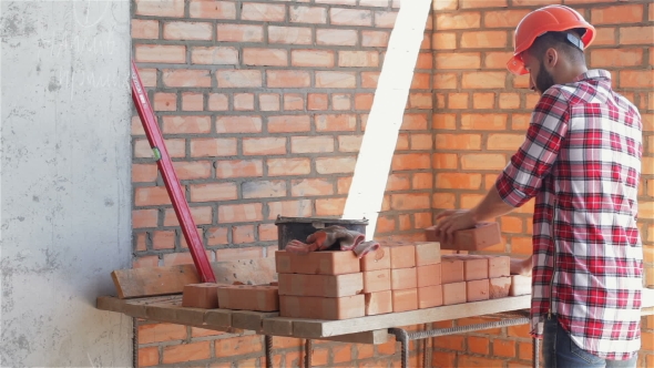 Builder Shifts Bricks At The Building Under Construction