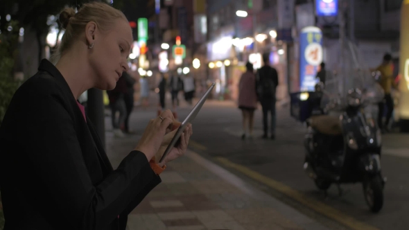 Woman Working With Pad In Night Seoul Street, South Korea