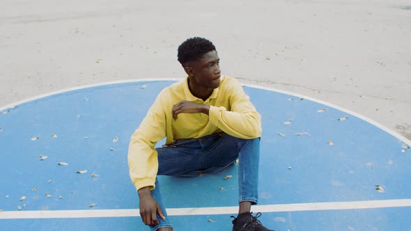 Portrait of a young man sitting on a playground