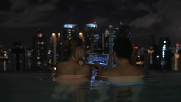 Couple With Pad In Rooftop Pool Of Night Kuala Lumpur