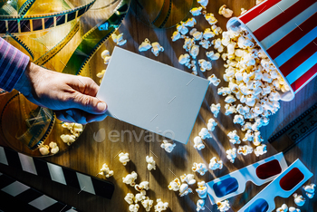 popcorn, filmstrip and clapper on the background; movies and entertainment concept
