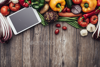 tablet on a rustic kitchen table, healthy food, cooking and technology concept