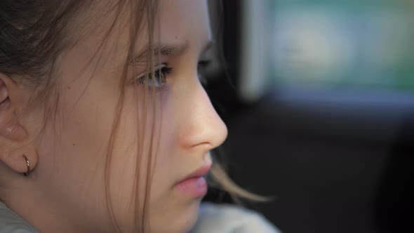 Sad Little Girl in the Car Looking Out the Window