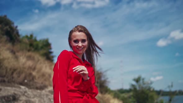 Sexy lady outdoors. Portrait of a young woman in red dress looking on camera