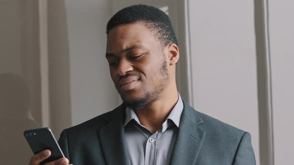 Frustrated African American Guy Look at Cell Phone Screen Reads Bad News in Mobile Message Concept
