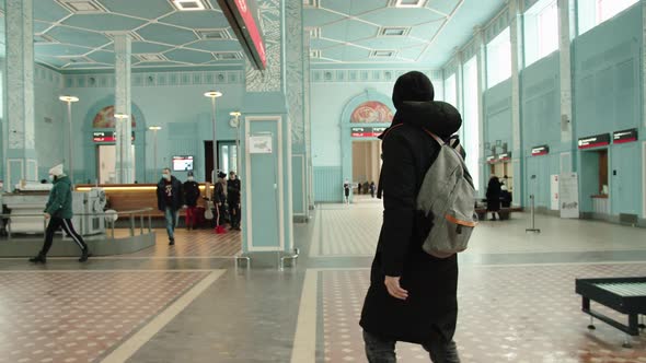 A Young Passenger Walks Through the Station