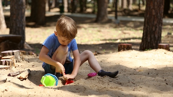 A Boy Plays in the Sandbox
