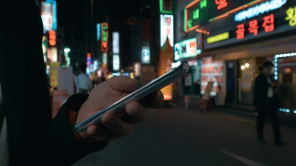 Woman Browsing Online On Cell In Night Seoul, South Korea