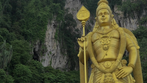 Murugan Statue Against Limestone Hill. Batu Caves, Malaysia