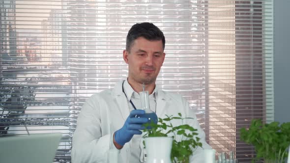 Close-up of Cheerful Scientist in Lab Coat Making Cheers with His Colleagues of Chemistry Laboratory alt