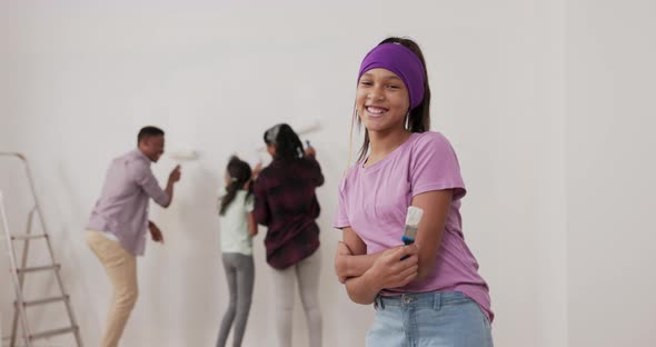 Renovation of Apartment Smiling Girl in a Purple Blouse and Headband Looks Into the Camera Holds a