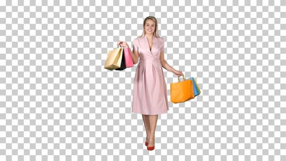 Young blonde girl in pink dress showing to camera shopping