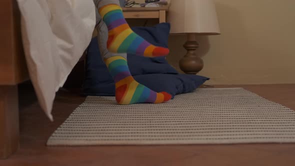Woman getting out of bed wearing striped socks