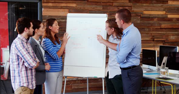 Business executives discussing over white board