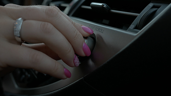 Car Interieur Female Hand Pump up the Volume. Tune Control in the Car.