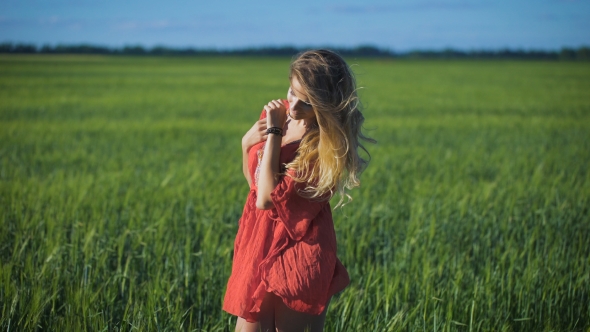 Charming Blonde Woman At a Green Field