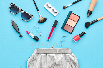 Set. Essentials. Fashion Design. Lipstick Brushes Eyeshadow, fashion Glamor Stylish Silver Clutch. Minimal Concept. Top view.Cosmetic Overhead