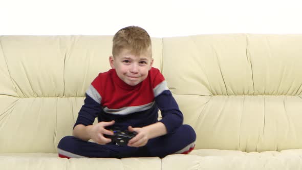 Boy with Games Console Playing Video Game on the Sofa