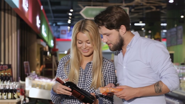 Young Couple Choose Wine At The Supermarket