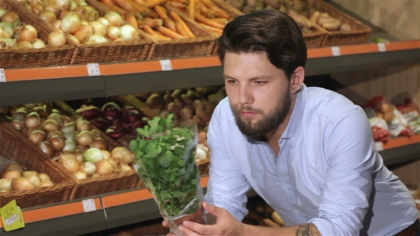 Man Smells Basil At The Supermarket