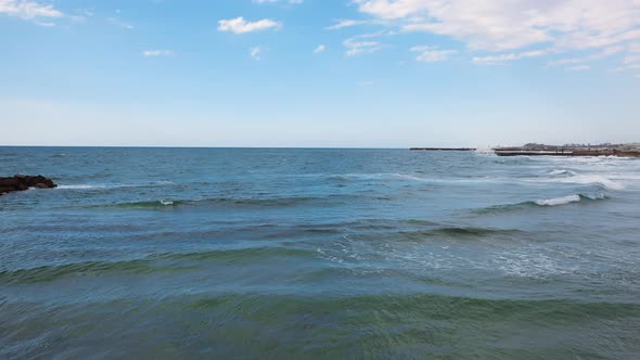 Sea and sky with gentle rolling waves and surf from aerial view on a sunny day. Location is Tel Aviv