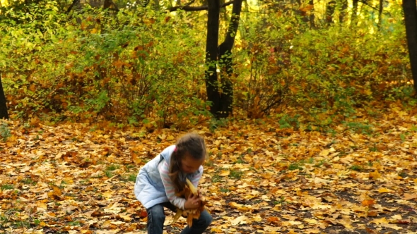Girl Throws Up Autumn Leaves in the Park