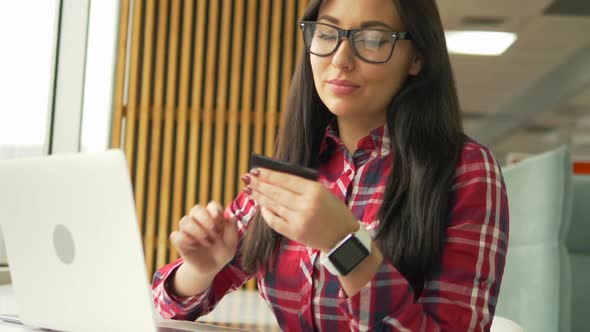 Young Mixed Race Hipster Woman Holding Credit Card and Using Laptop Computer