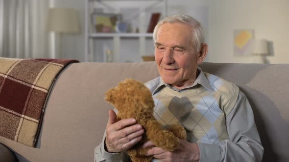 Happy Senior Man Hugging Teddy Bear, Remembering Grandchildren, Family Care