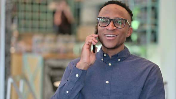 Cheerful African Man Talking on Smartphone