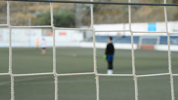 Children Goalkeeper in a Football Game Behind the Goal