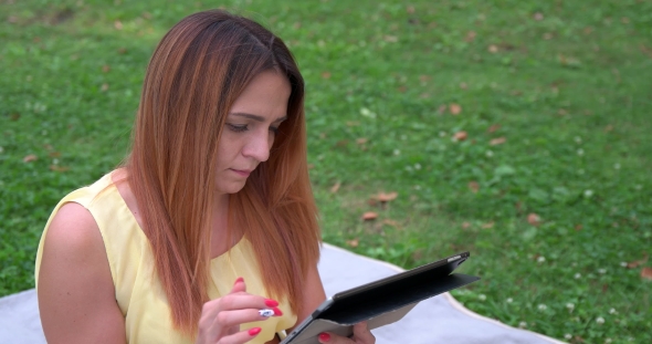 Beautiful Girl In The Park With Tablet