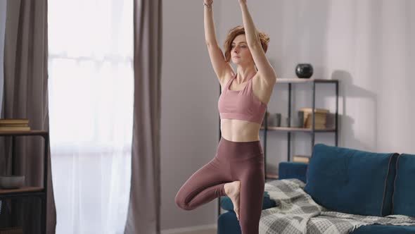 Yoga Practice of Adult Woman in Living Room Sporty Lady is Doing Balance Exercise Standing on One