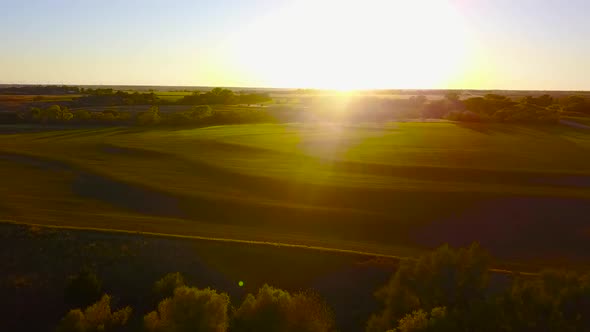 Aerial drone shot of a tiered wheat field in Kingman, Kansas, at sunset. The field is about 30 minut