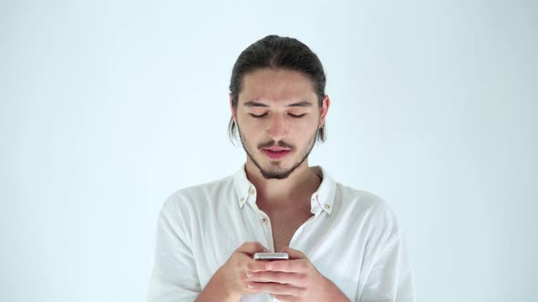 Handsome guy using mobile phone, texting message on smartphone.