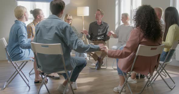 Young People Holding Hands Together During Group Therapy