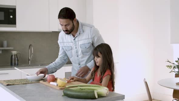 Girl Helping Her Dad To Cook Salad