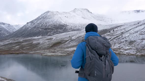 A Man Travels with a Backpack Along the Mountain Routes. He Meets Beautiful Landscapes and Enjoys