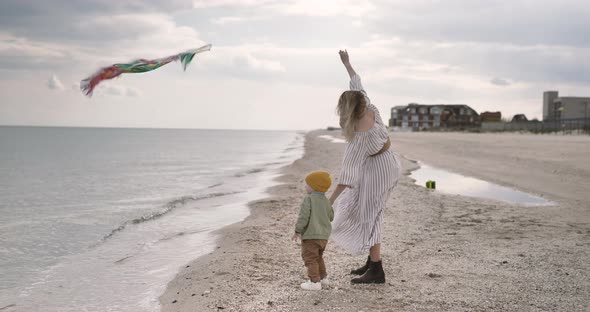 Mom and son together launch kite. Parents spend time with a child. Happy family concept.