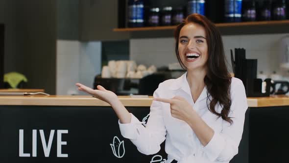 Pretty Worker in Formal Clothes Pointing To Something on Arm in the Cafe