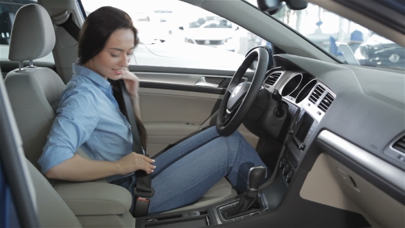 Woman Sits Inside the Car at the Dealership