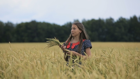 Beautiful Young Teen Girl With Ears Of Wheat In a Wheat Field.