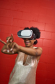 Cool millennial black woman exploring space with virtual reality glasses by a red concrete wall - PhotoDune Item for Sale