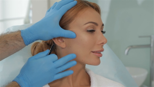 Cosmetologist Stretches The Skin On Client's Cheek