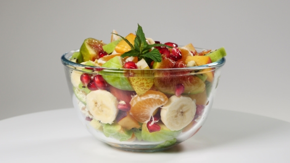 A Fruit Salad With Mandarin, Oranges, Kiwi, Pomegranate Seeds, Figs, Banana And Peaches