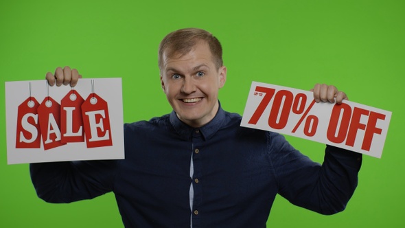 Cheerful Man Showing Sale Word and Showing Up To 70 Percent Off Inscription. Black Friday Concept