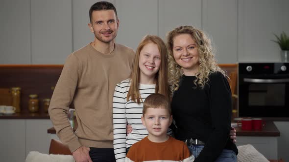 Portrait of Happy Family Smiling at Camera Indoors