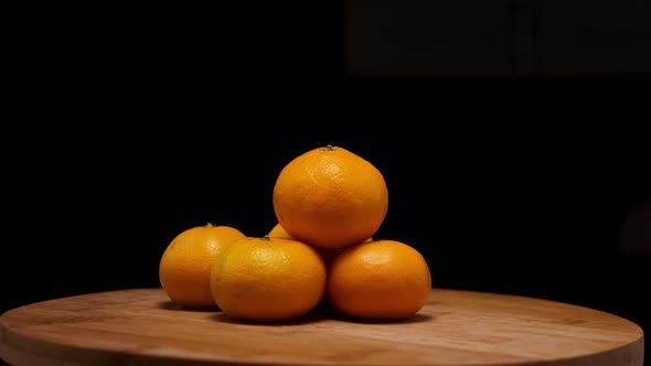 Yellow ripe tangerines on a wooden background. The camera flies around. Parallax effect
